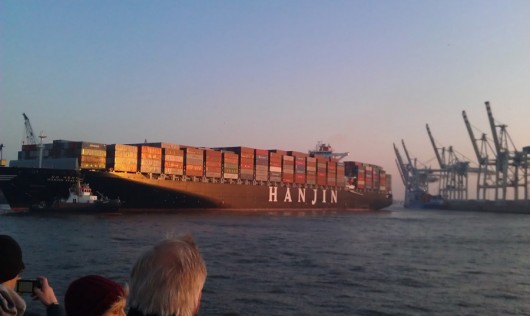 Ein mittelgroßes Containerschiff beim rückwärts Anlegen.