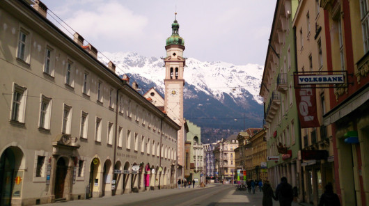 Eine der Haupteinkaufsstraßen in Innsbruck, im Hintergrund die Alpen.