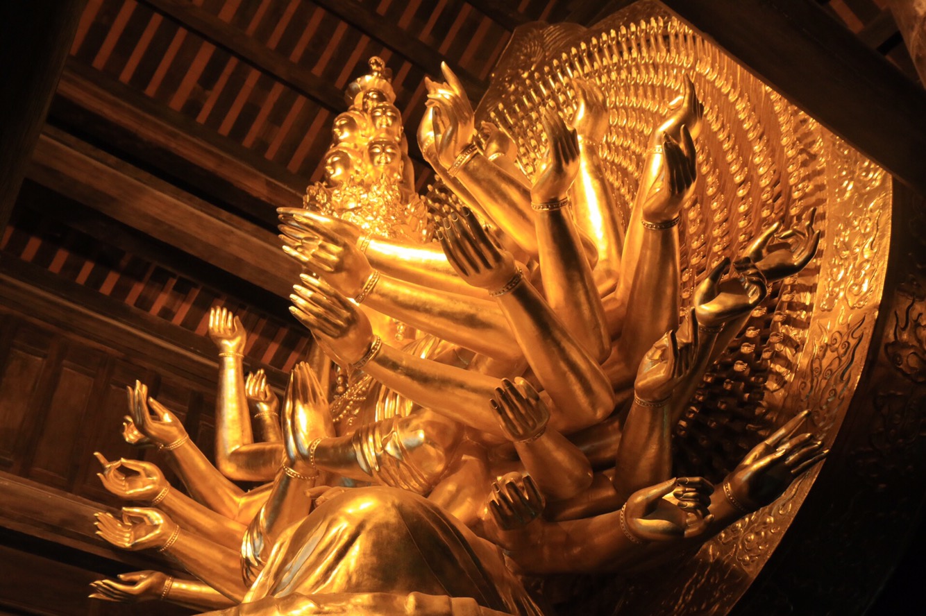 Im Inneren der Haupthalle ein vielarmiger Buddha.