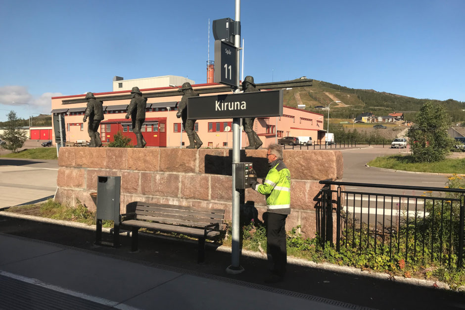 Hier unser Zugchef bei der Abfertigung des Zuges. Im Hintergrund ein Denkmal, das an den Bau der Strecke erinnert.