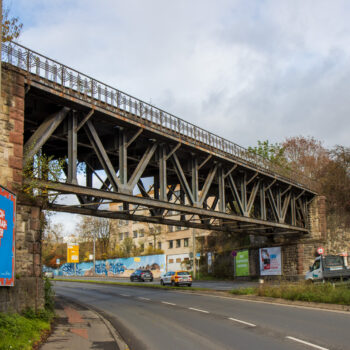 Am Ortschild von der A671 kommend überquert diese schöne Eisenbrücke die Schnellstraße.