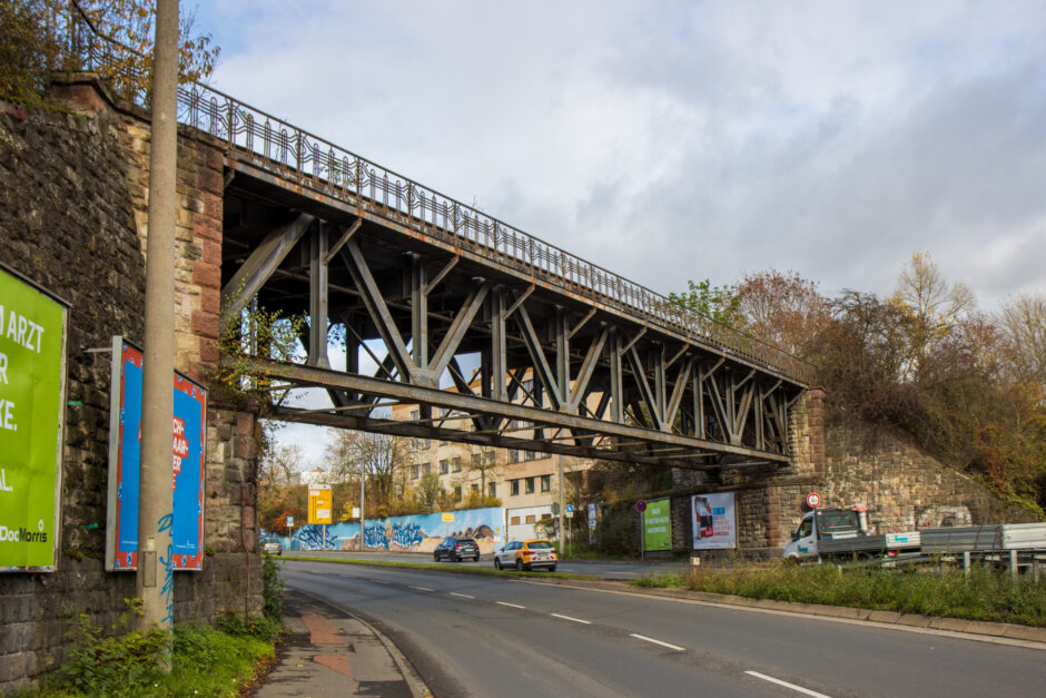 Am Ortschild von der A671 kommend überquert diese schöne Eisenbrücke die Schnellstraße.