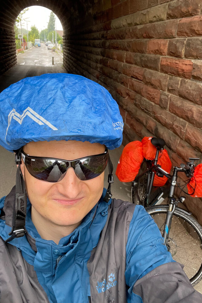 Ein Selfie mit dem sexy Regenschutz über dem Helm. Aber er hält dicht und nur das zählt.